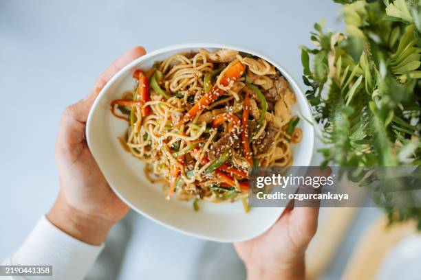 radiant asian waitress serving gourmet meal - wok stockfoto's en -beelden