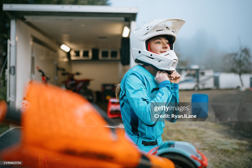 Young Woman Motocross Racing Puts on Helmet