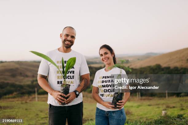 couple of volunteers holding tree seedlings - molting stock pictures, royalty-free photos & images