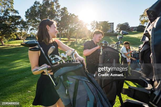diverse young adults enthusiastically preparing for golf game - golf bag stock pictures, royalty-free photos & images