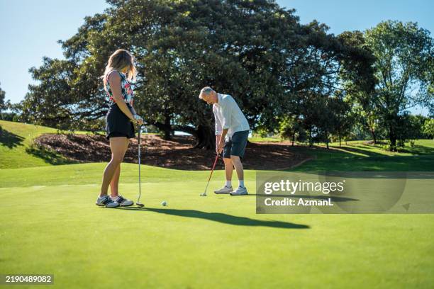 joyful mature caucasian couple enjoys golf - putting golf stock pictures, royalty-free photos & images