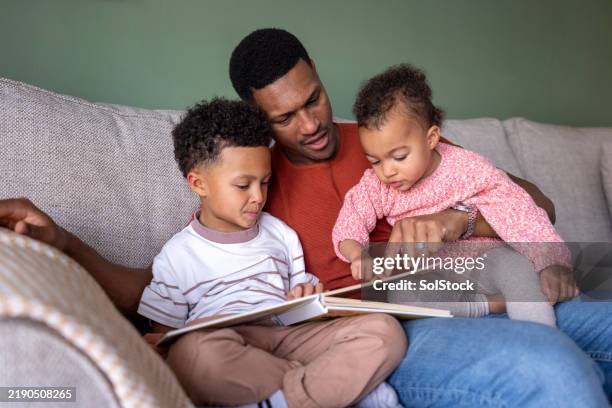 dad reading a storybook to the children - verhalen vertellen stockfoto's en -beelden