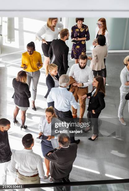 engaged diverse professionals collaborate at business conference - sociale bijeenkomst stockfoto's en -beelden