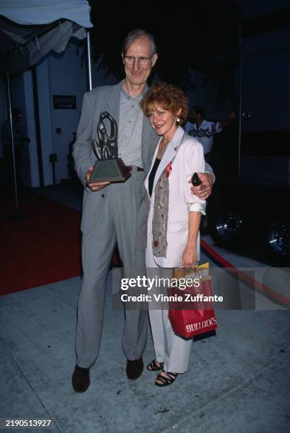 American actor James Cromwell, wearing a grey suit over a grey shirt, and his wife, American actress Julie Cobb, who wears a white trouser suit,...