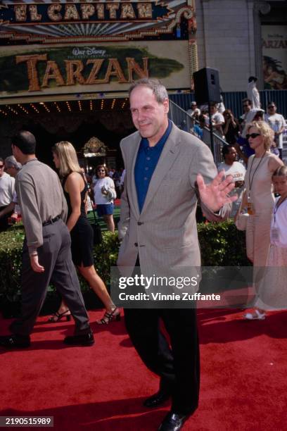 American media executive Michael Eisner, Walt Disney Company chief executive officer, wearing a grey blazer over a blue shirt with black trousers,...