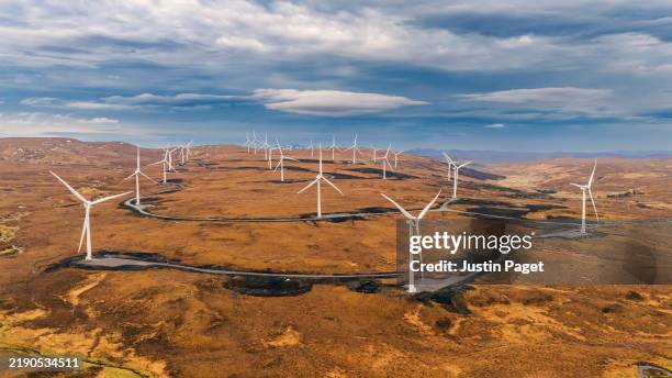 an aerial/drone view of wind turbines in a remote location in the scottish highlands - scottish highlands stock pictures, royalty-free photos & images