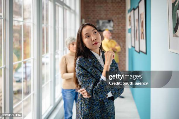 art gallery scene with people observing framed artwork on display - espetáculo de arte imagens e fotografias de stock