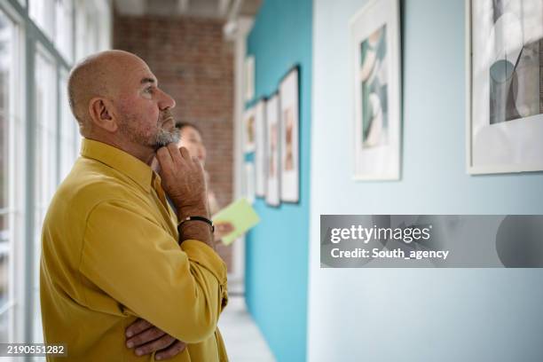 art gallery visitors appreciating curated exhibitions on display in a modern environment - espetáculo de arte imagens e fotografias de stock