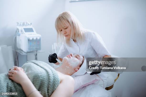 professional facial application. close-up of a white cream mask being applied to the skin with a brush. skincare treatment. - spa treatment stock pictures, royalty-free photos & images