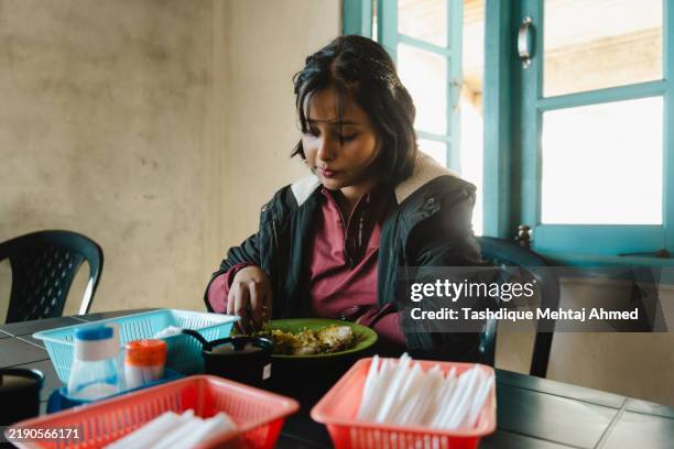 young woman having food at a food stall. - south asia stock pictures, royalty-free photos & images