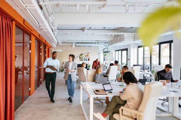 modern collaborative office space with diverse professionals working in a co-working environment - modern stock pictures, royalty-free photos & images
