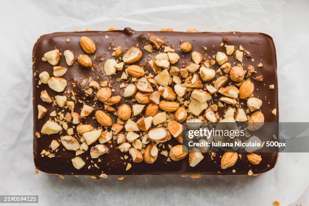 a rectangular chocolate confection with a glossy chocolate coating - chocolate and nuts stock pictures, royalty-free photos & images