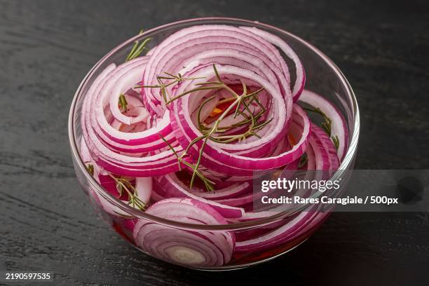 a clear glass bowl filled with thinly sliced marinated red onions - spanish onion stock pictures, royalty-free photos & images
