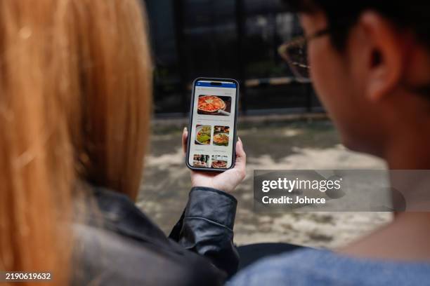 friends choosing from a digital menu at a cafe - back alignment stock pictures, royalty-free photos & images