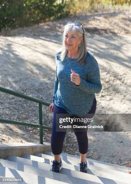 femme âgée montant des marches extérieures pour faire de l’exercice - activité physique photos et images de collection