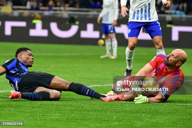 Como's Spanish goalkeeper Pepe Reina gathers the ball at the feet of Inter Milan's Dutch defender Denzel Dumfries during the Italian Serie A football...