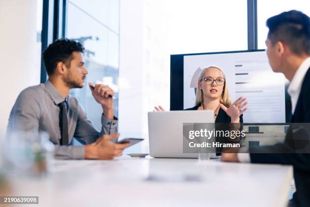young professionals engaged in a dynamic business meeting in a modern office setting - debat stockfoto's en -beelden