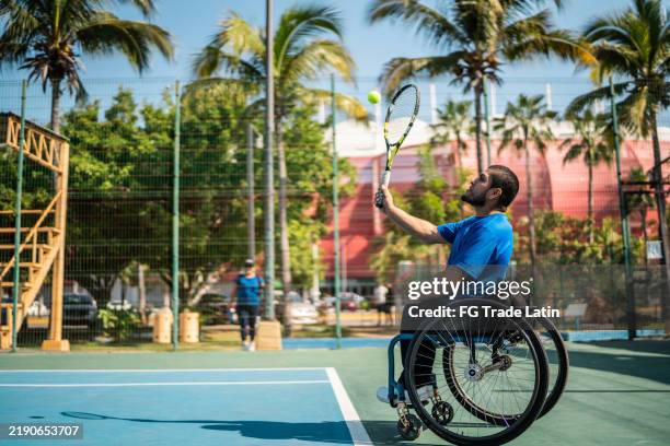 young wheelchair tennis player man playing at tennis court - wheelchair tennis stock pictures, royalty-free photos & images