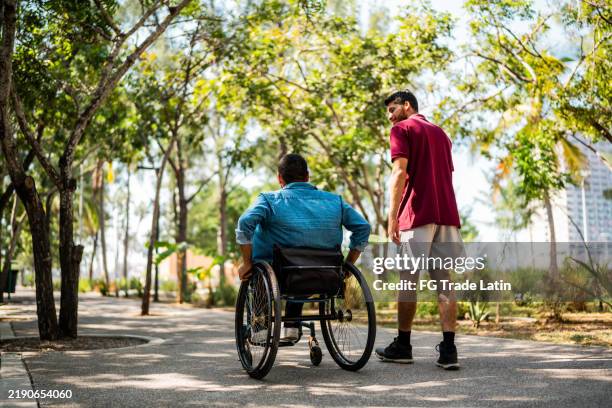 friends talking and walking on public park - pessoas com deficiência imagens e fotografias de stock