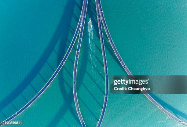 drone aerial view of jiaozhou bay bridge of qingdao, shandong province, china - balkengerüst stock-fotos und bilder