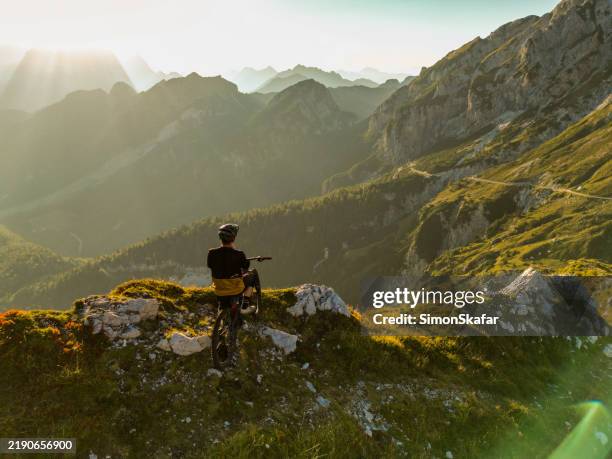 mountain biker enjoys sunset vista - extreme dedication stock pictures, royalty-free photos & images