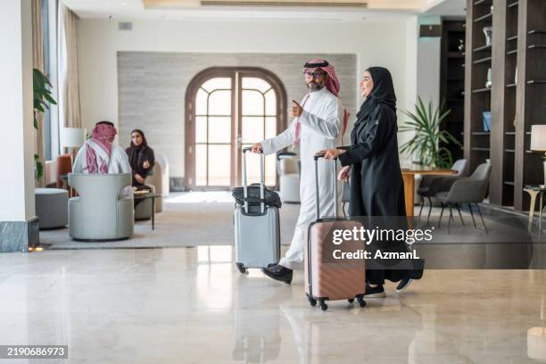 joyful arabic couple enjoying luxurious hotel check-in - saudi arabia people stock pictures, royalty-free photos & images