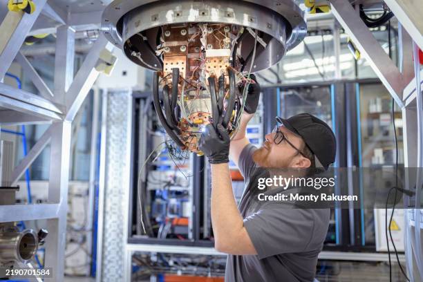 engineer assembling a high temperature superconducting magnet (hts) used to control hot plasma inside a nuclear fusion reactor - science and technology stock pictures, royalty-free photos & images