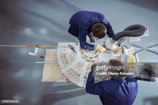 engineers winding high temperature superconducting (hts) tapes for use in nuclear fusion reactor - kernfusion stock-fotos und bilder