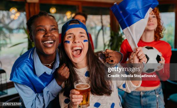 people watching soccer game in pub cheering - supporter stock pictures, royalty-free photos & images