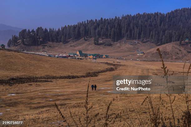 People walk at the famous ski resort Gulmarg amid dry weather conditions in Baramulla, Jammu and Kashmir, India, on December 24, 2024. There is no...