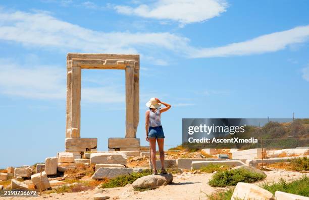 female tourist looking at temple of apollo mid day - templo de apolo naxos imagens e fotografias de stock