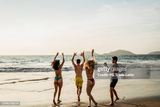 friends celebrating and running on the beach - mazatlan stock pictures, royalty-free photos & images