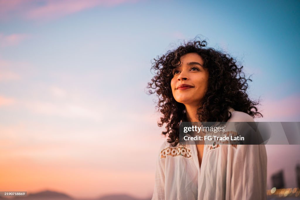Junge Frau, die auf die Aussicht schaut und im Freien nachdenkt