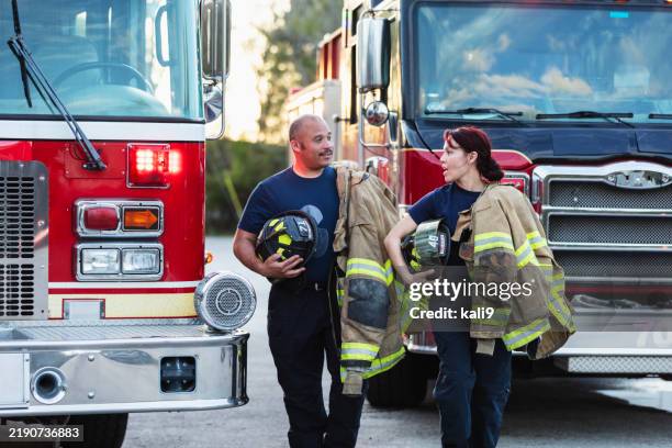 deux pompiers multiraciaux portant des équipements de protection - pompier photos et images de collection