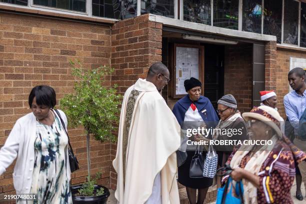 Parish priest of Regina Mundi Church, Fr Nqobile Mzolo OMI gives gifts to parishoners at the end of the Christmas Mass at Regina Mundi Church in...