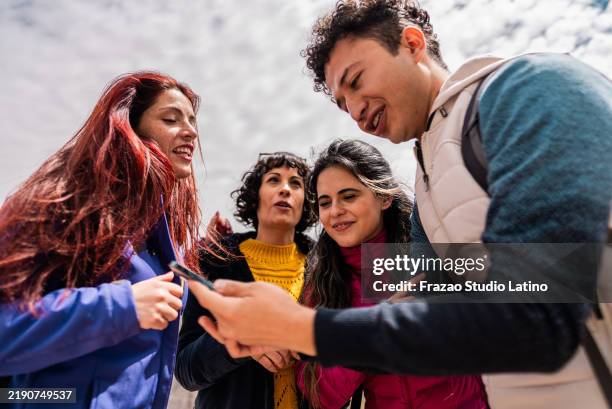 tourist man showing mobile phone to friends on a mountain, in cajon del maipo, chile - chilean people stock pictures, royalty-free photos & images