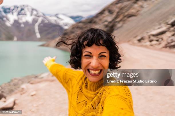 tourist woman taking a selfie or filming on a mountain, in cajon del maipo, chile - camera point of view - chilean people stock pictures, royalty-free photos & images