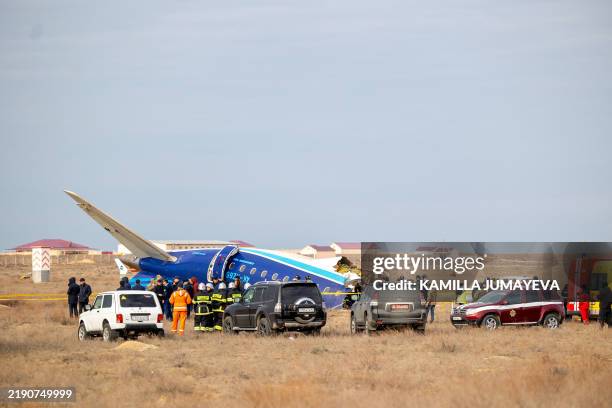 Emergency specialists work at the crash site of an Azerbaijan Airlines passenger jet near the western Kazakh city of Aktau on December 25, 2024. /...