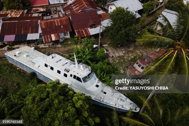 This aerial view shows two patrol boats washed ashore by the 2004 Indian Ocean tsunami and preserved at the community's in Banda Aceh on December 25...