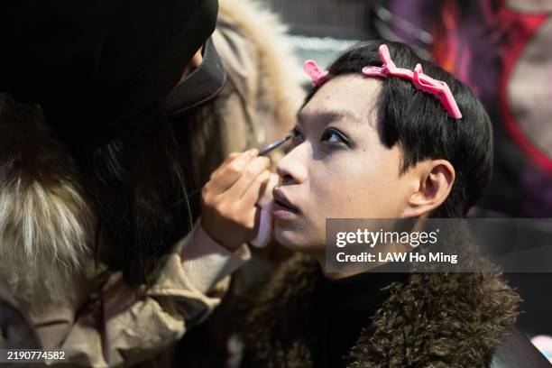 a young and fashionable male is putting on makeup. - makeup artist stock pictures, royalty-free photos & images