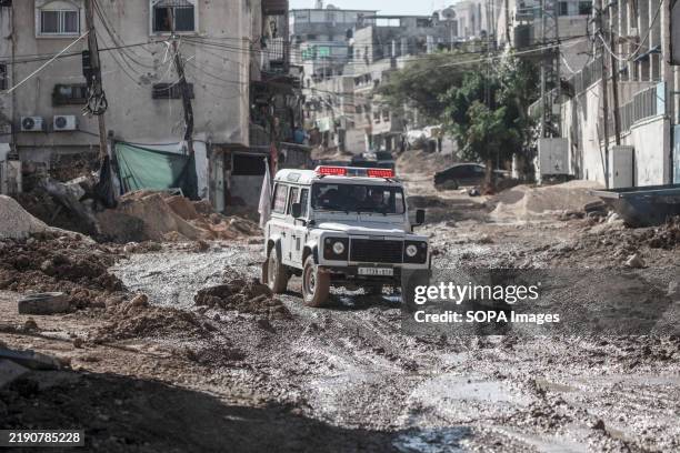 Palestinian Red Crescent jeep delivers aid to citizens in the middle of a destroyed market during an Israeli raid on Tulkarm refugee camp in the West...