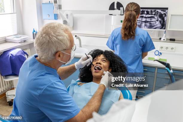 patient receiving professional dental care with advanced equipment and an x-ray in view - angled mirror stock pictures, royalty-free photos & images