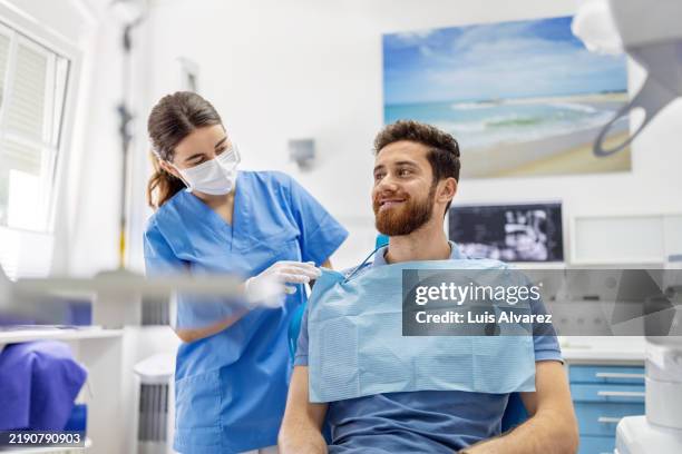 dental assistant preparing patient for dental therapy at dentist office - prevención de enfermedades fotografías e imágenes de stock