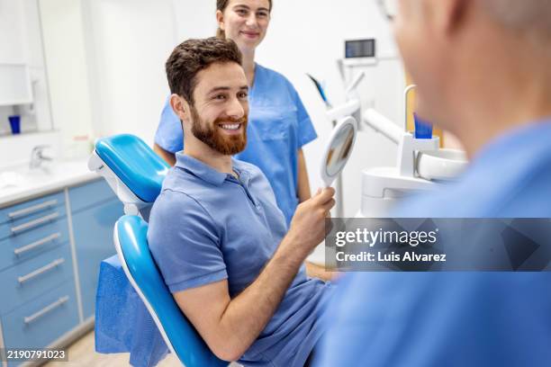 dentist and patient discussing dental care options. - cara a cara fotografías e imágenes de stock