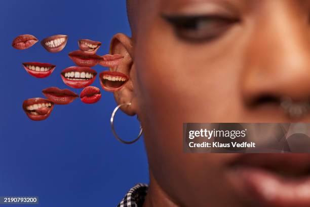 non-binary person with cut outs of lips near ear - mouth stock pictures, royalty-free photos & images
