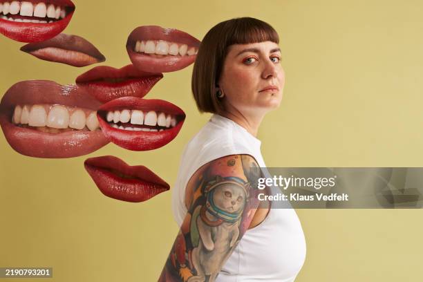 woman with tattooed arms near mouth cut outs - animal representation stock pictures, royalty-free photos & images