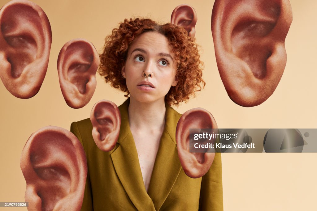 Curly haired non-binary person amidst ears cut out