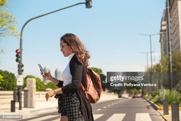 woman walking on the crosswalk in the city - mv ventura stock pictures, royalty-free photos & images