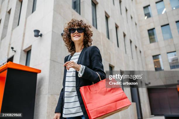 junge frau, die einkaufstüten in shanghai in china trägt - geschenktüte einwickelpapier stock-fotos und bilder