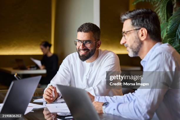 male entrepreneur sitting next to colleague - middle eastern culture stock pictures, royalty-free photos & images